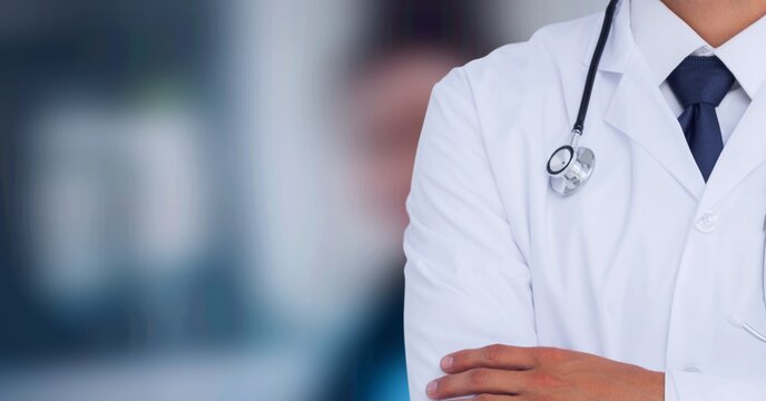 Composition of midsection of male doctor in lab coat with stethoscope over out of focus hospital
