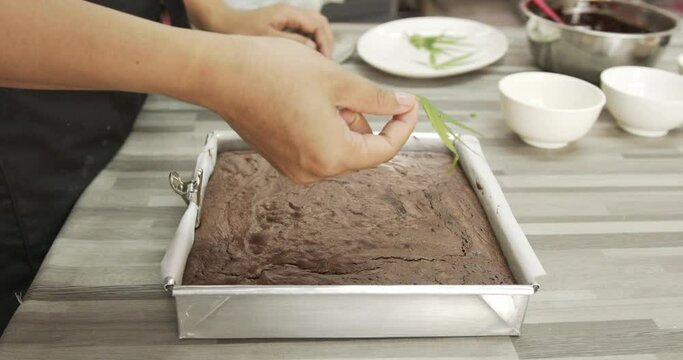 Marijuana leaves are placed on top of chocolate brownies, Concept of cooking with cannabis herb, Treatment of medical marijuana for use in food.