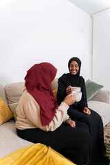 Two Black Muslim women having cake and dessert at home