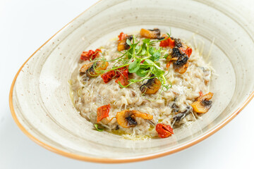 rice, vegetables, mushrooms, greens, bright juicy beautiful risotto with mushrooms, tomatoes and herbs in a plate on a light background, close-up, restaurant serving