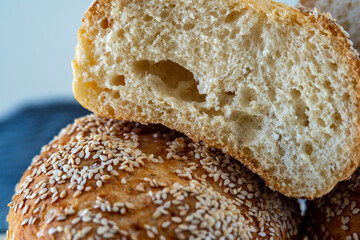 Closeup on a slice of fresh challah bread roll showing texture, air pockets and crust. Macro crumb shot of gluten free bread bun hot from the oven cut into half. Fluffy homemade bread bun with sesame 