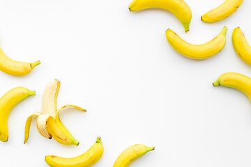 Whole and peeled bananas flay lay. Fruits pattern. Top view