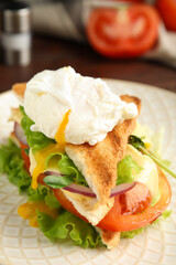 Tasty sandwich with poached egg on plate, closeup