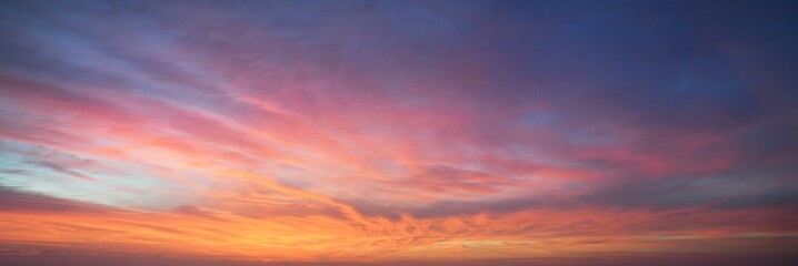 Clear blue sky. glowing pink and golden cirrus and cumulus clouds after storm, soft sunlight. Dramatic sunset cloudscape. Meteorology, heaven, peace, graphic resources, picturesque panoramic scenery