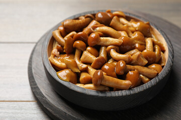 Delicious marinated mushrooms on wooden table, closeup