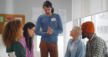 Young man speaking at group counseling therapy session looking for support in addiction treatment