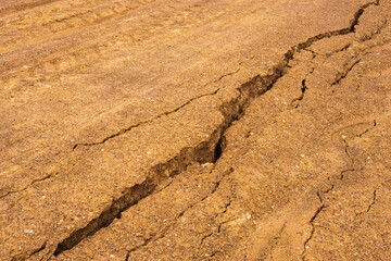 Background gravel surface which is water erosion, cracking and erosion.