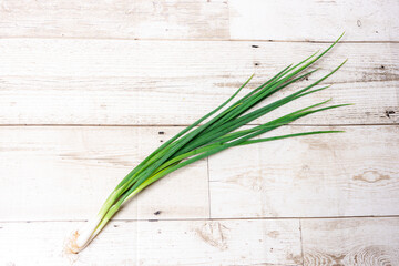 Leek, large bunch of green onions on board, food, Close up chopped fresh spring onion on rustic wood table in top view flat lay with copy space. Prepare scallions for cooking. Food and