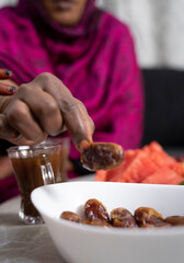 Black Muslim woman reaching for dates