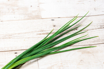 Leek, large bunch of green onions on board, food, Close up chopped fresh spring onion on rustic wood table in top view flat lay with copy space. Prepare scallions for cooking. Food and vegetable conce