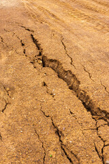 Background gravel surface which is water erosion, cracking and erosion.