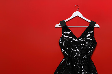 Beautiful dress and hangers on red background, flat lay. Rental clothing service