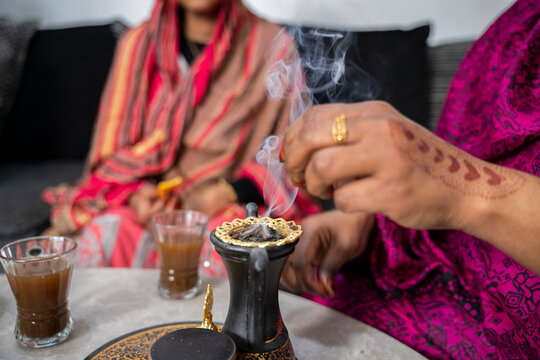 Black Muslim women putting on incense 