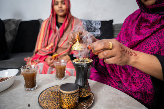 Black Muslim women putting on incense 