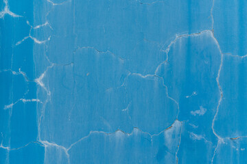 Blue wall with paint cracks and aging stains. Texture wallpaper background.