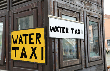 Sign with the inscription WATER TAXI which are the special boats for the transport of people in the city of Venice