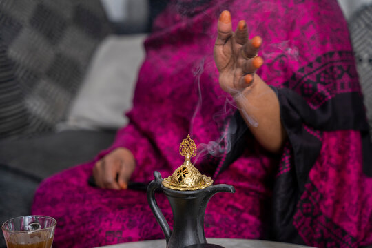 Black Muslim woman putting on incense 