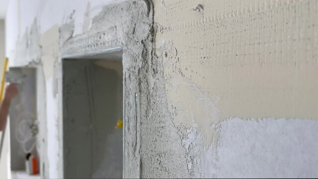 Plasterer applies plaster to the wall at repair renovation work 