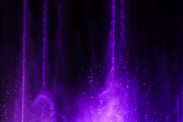 Splashing fountain in purple color at night