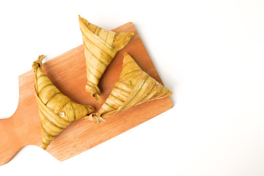 Ketupat palas or rice dumpling on wooden board. Ketupat palas is a natural rice casing made from young coconut leaves or cooking rice during Eid Mubarak or Eid Fitri.