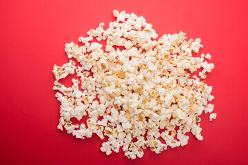 Heap of delicious popcorn isolated on background. Scattered popcorn texture background. Selective focus.