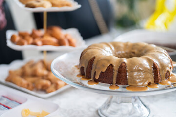 Eid dessert table with brown cake and snacks in the background