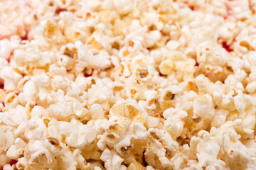 Heap of delicious popcorn isolated on background. Scattered popcorn texture background. Selective focus.