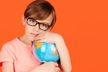 Cute school boy hugging the earth globe. Save the earth. Happy kid in glasses holding Earth world globe.