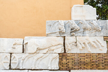 Beautiful sculptures of horses carved on ruins of ancient marble wall in Rome