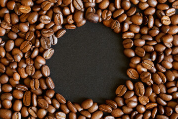 A black circle inside the roasted coffee beans scattered on the surface. Design template for inserting text or images about coffee, breakfast or lifestyle