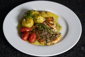 fresh cooking at home and ready to eat - grilled salmon fillet with rosemary, cherry tomatoes and fried potatoes in butter and herbs