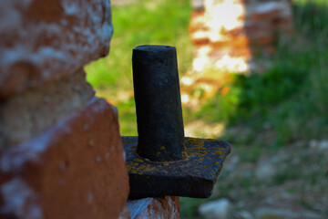 Close-up of an old rusty metal castle door hinge. Metal door hinge on a brick wall. Overgrown with...