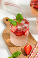 A refreshing summer drink with strawberries, lime and mint in a glass. Ice-cold summer lemonade.