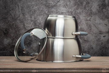 Food pan, stainless steel, on a wooden countertop, against a stuccoed wall