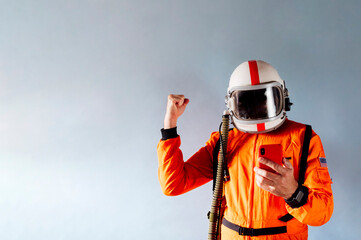 Man with astronaut suit and mobile phone.