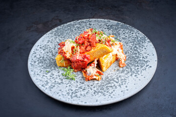 Modern Style traditionelle italienische Polenta alla Sarda con Salsiccia mit Rohwurst serviert als Draufsicht auf einem Nordic Design Teller mit Textfreiraum