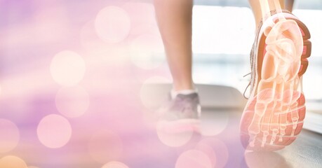 Composition of spots of light over woman running on treadmill with foot bones showing