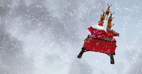 Composition of santa claus in sleigh pulled by reindeer on snowfall and clouds background