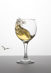 Wineglass with white wine with splash