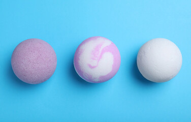 Colorful bath bombs on light blue background, flat lay