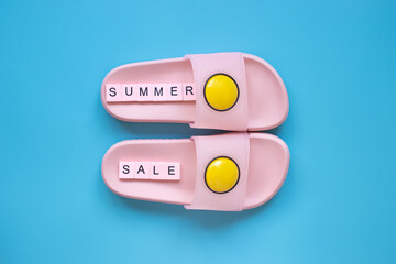 Summer sale background. Pink slippers on a blue background.