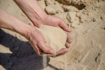 Man holding sand in his hands selective focus