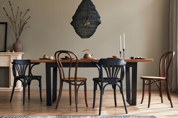 Stylish rustic interior of dining room with walnut wooden table, retro chairs, decoration,...