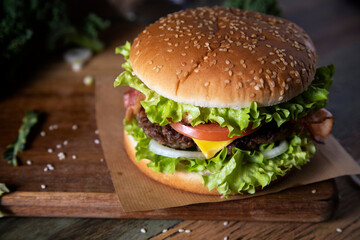Homemade hamburger with bacon on a rustic table