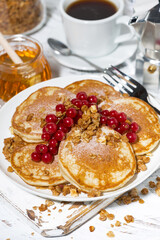 delicious pancakes with berries and honey for breakfast, top view