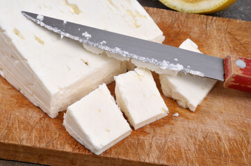 Morceau de feta sur une planche à découper avec un couteau en gros plan