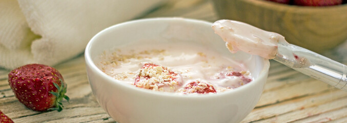 Homemade strawberry face mask with oatmeal and cream on a dark banner. Concept of natural handmade cosmetics