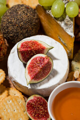 delicious snacks, cheese, crackers and fresh fruits, vertical closeup