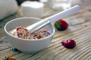 Homemade strawberry face mask. DIY natural home cosmetics mask with oatmeal, cream, strawberries. Authentic wellness cosmetics, natural skin care, non-waste production, sustainable cosmetics