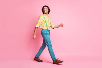 Full size photo of young happy smiling cheerful good mood positive man go walk look copyspace isolated on pink color background